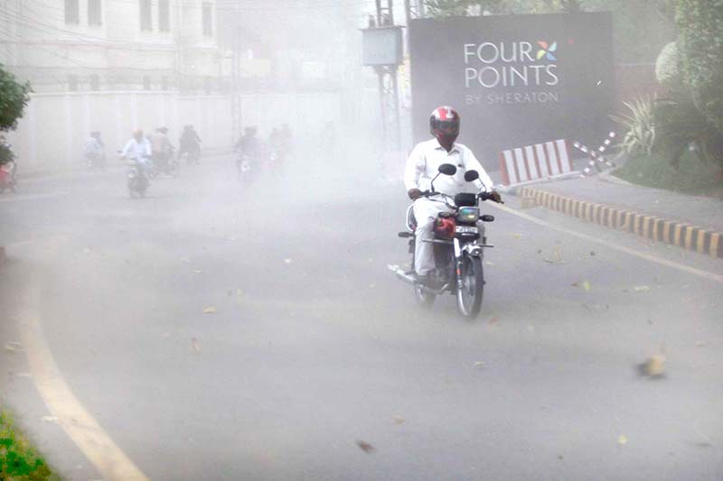 Motorcyclists strugling to move during a wind strom in the city