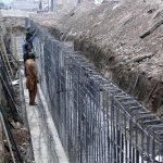 Laborers are engaged in the construction work of a flyover at Muzaffarabad Road