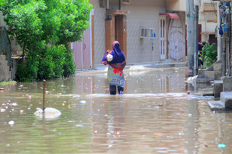 Gypsy people covering their makeshift home with polythene sheets to protect them from the rain near Vehari Chowk
