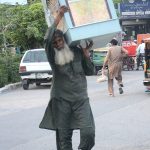 A man carrying air cooler on his shoulder