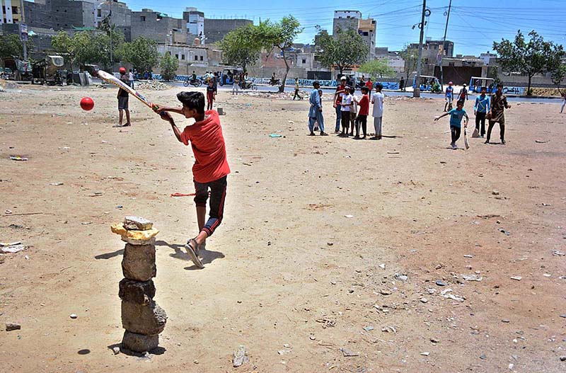 Children playing cricket in a local ground at Korangi area