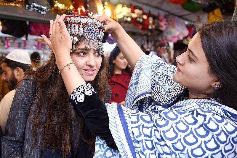 Female visitors selecting and purchasing artificial jewelry from a roadside vendor during their visit