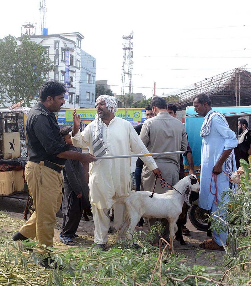 Policemen removing illegal sacrificial animals sellers from footpath in Korangi area