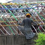 A gypsy person assembling a makeshift home on a roadside