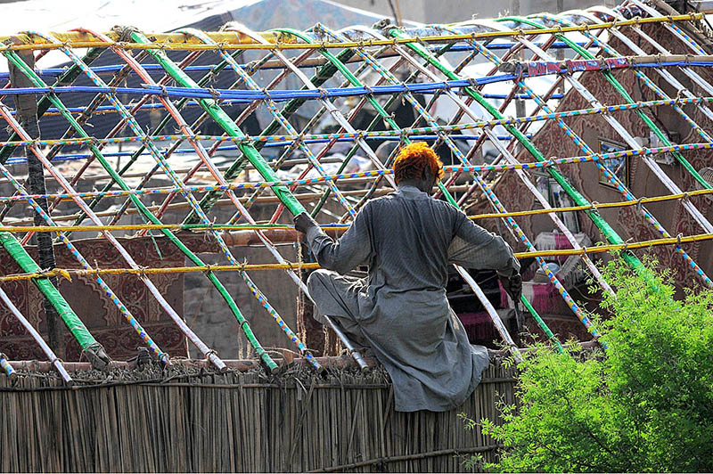 A gypsy person assembling a makeshift home on a roadside