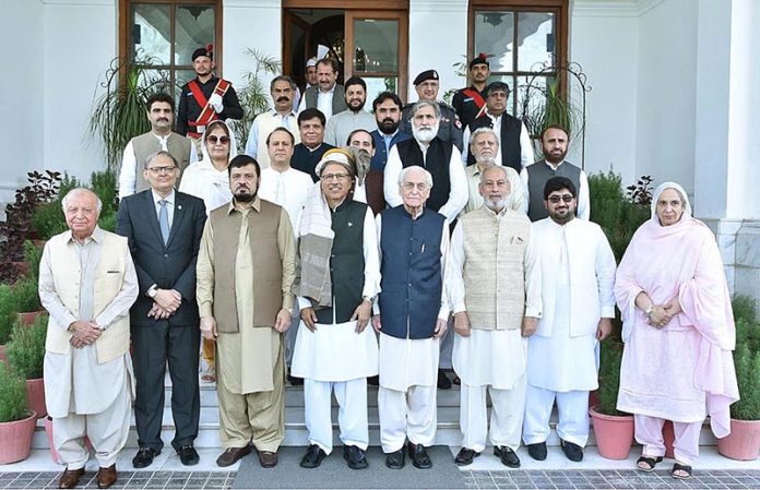 President Dr. Arif Alvi in a group photo with the Governor Khyber Pakhtunkhwa (KP), Haji Ghulam Ali, Caretaker Chief Minister KP, Muhammad Azam Khan, and members of the provincial cabinet, at Governor House