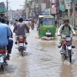 Commuters faces a challenging task of crossing stagnant water amidst heavy rainfall at kutchery road