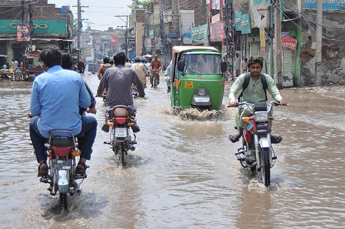 Commuters faces a challenging task of crossing stagnant water amidst heavy rainfall at kutchery road