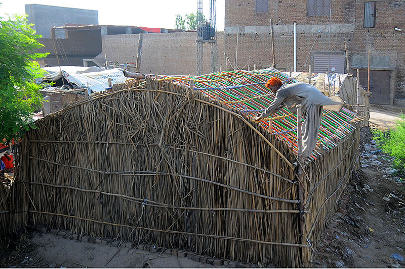 A gypsy person assembling a makeshift home on a roadside