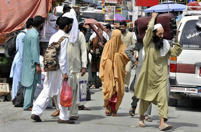 People with their luggage arrives at Faizabad Bus Stand to leave for their hometowns to celebrate Eid ul Azha with their loved ones