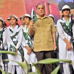 Prime Minister Mian Muhammad Shehbaz Shareef holding Pakistani Flag during National song being play at Sabzazar Sports Complex