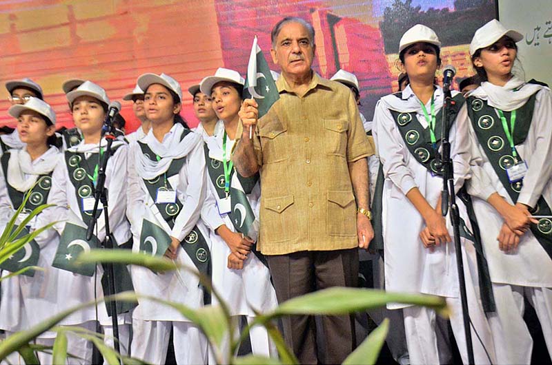 Prime Minister Mian Muhammad Shehbaz Shareef holding Pakistani Flag during National song being play at Sabzazar Sports Complex
