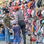 A vendor selling caps at his roadside setup in Provincial Capital