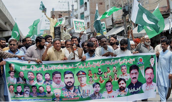 People participating in a walk-in rally to express their solidarity with the Pak army organized by Pasban Rickshaw Taxi Driver Union Register Punjab at Chowk Aziz