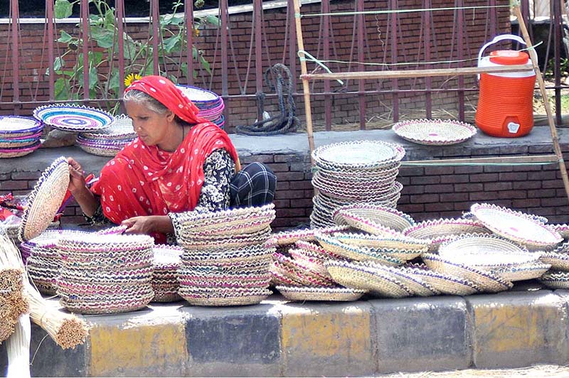 An elderly woman vendor arranging and displaying handmade items to attract customers the customers at roadside setup