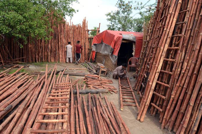 Workers busy in preparing ladder with bamboos at his workplace