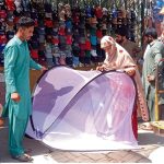 A Woman purchasing mosquito nets from a roadside stall