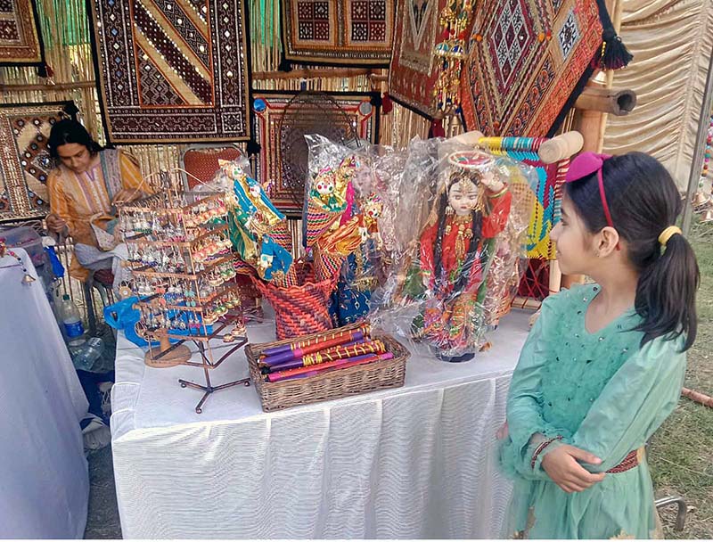 Young girls wearing traditional Kashmiri caps and posing for photograph during Saqafati Mela promoting Pakistani culture providing entertainment to public at Lok Virsa