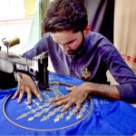 A worker busy in embroidery work on ladies wear at his workplace in connection with upcoming Eidul Azha