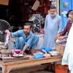 Vendor making mince for customers at his roadside set up on the second day of Eid ul Adha