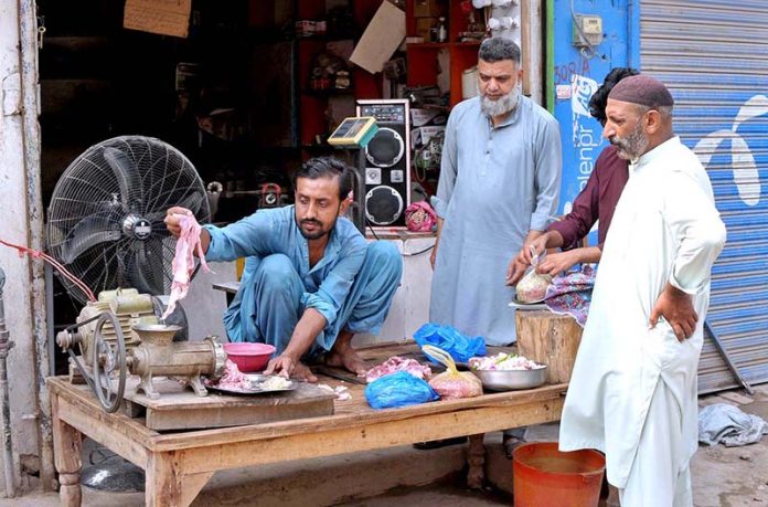 Vendor making mince for customers at his roadside set up on the second day of Eid ul Adha