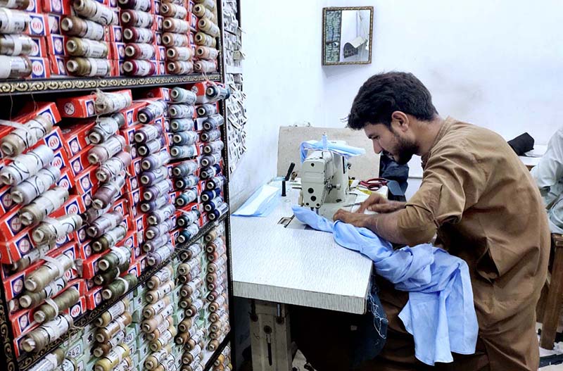 A worker busy in embroidery work on ladies wear at his workplace in connection with upcoming Eidul Azha