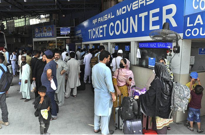 A large number of people purchasing tickets and waiting for transport to travel their hometowns at Faizabad Bus Stand to celebrate Eid ul Azha with their loved ones