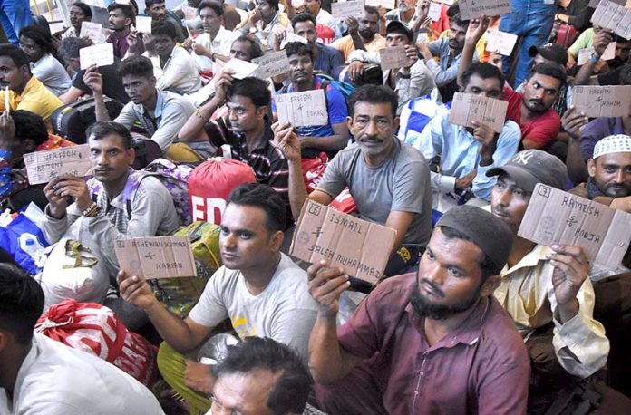 Indian fishermen show their identity cards at Lahore Railway Station after Pakistan authorities released them, allegedly arrested for trespassing into its territorial waters
