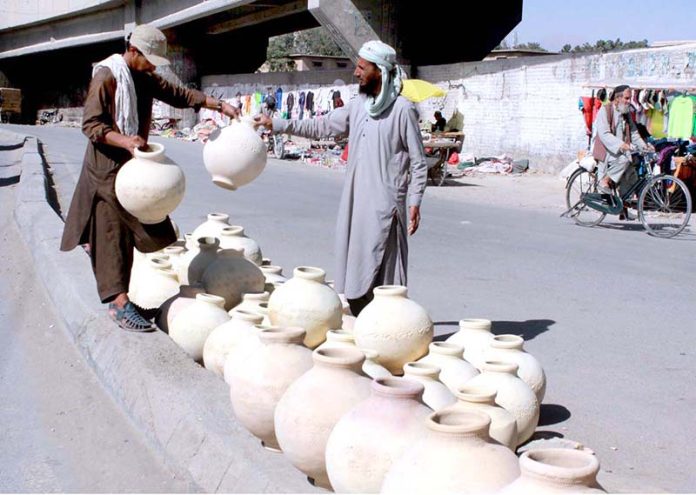 Vendor decorating pithos (matka) for customers which demands increased in hot weather at Joint Road