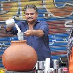 A vendor selling a traditional summer drink (Lassi) at his roadside setup