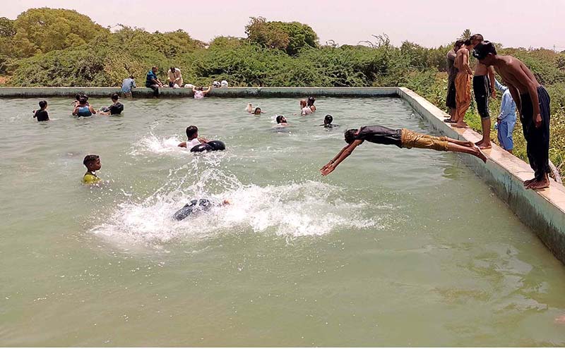 Youngsters jumping into a swimming pool for bathing to get some relief from hot weather in the city