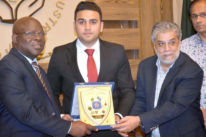 Acting President Wahab Jahangir presenting a shield to Ambassador Muhammad Bello Abioye high commissioner Nigeria to Pakistan at SCCI