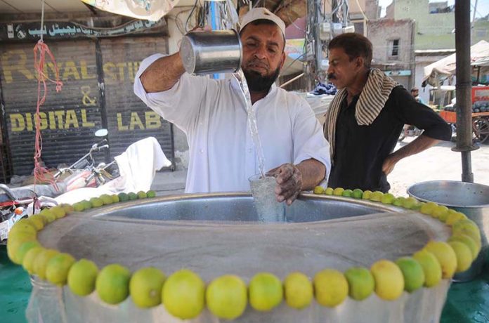 A vendor preparing a traditional summer drink (Shikanjabeen) to attract the customers at Ghanta Ghar Chowk