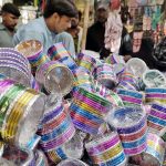A vendor displaying colourful bangles to attract the customers at Resham Gali in connection with upcoming Eidul Azha