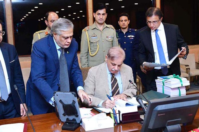 Prime Minister Muhammad Shehbaz Sharif signing Budget 2023-24 documents after its approved by the Cabinet to be laid before the National Assembly