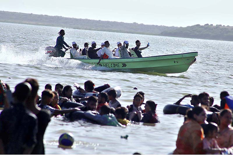 A large number of people enjoy bathing at keenjhar Lake during hot day in the city