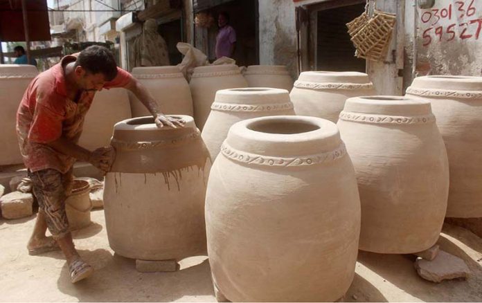 An artisan is busy in preparing a traditional oven “Tandoor” at his workplace