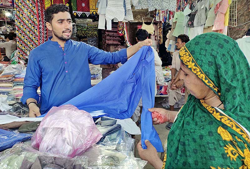 A vendor displaying colourful bangles to attract the customers at Resham Gali in connection with upcoming Eidul Azha