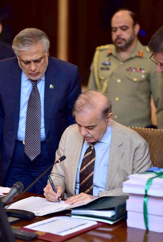 Prime Minister Muhammad Shehbaz Sharif signing Budget 2023-24 documents after its approved by the Cabinet to be laid before the National Assembly