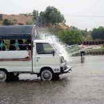 A person washing his vehicle in a local stream at Dando Pull area near Phandu