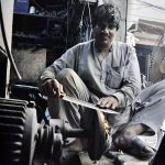 A blacksmith busy in sharpen knives to be used for slaughtering sacrificial animals during Eidul Azha