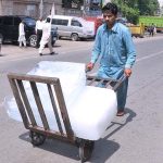 A labourer pushing handcart loaded with ice block to deliver in a local market as demand increased due to hot weather in Provincial Capital