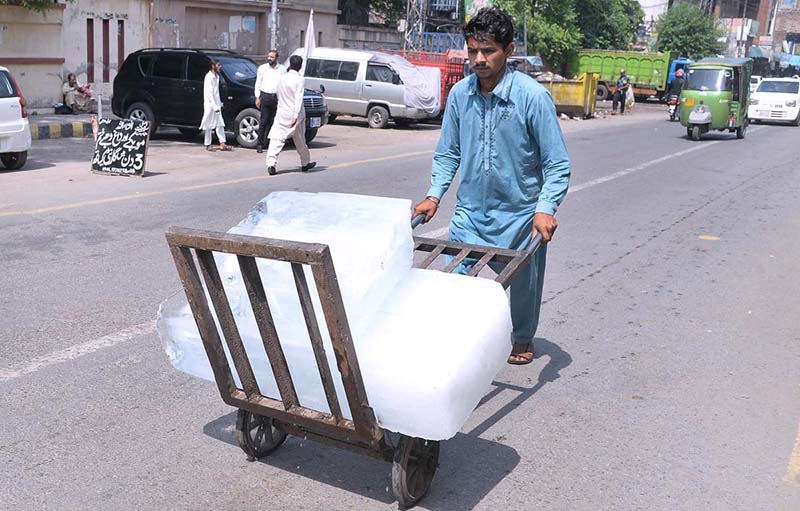 A labourer pushing handcart loaded with ice block to deliver in a local market as demand increased due to hot weather in Provincial Capital