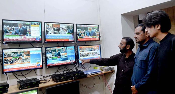 People listening the Federal Budget speech on TV