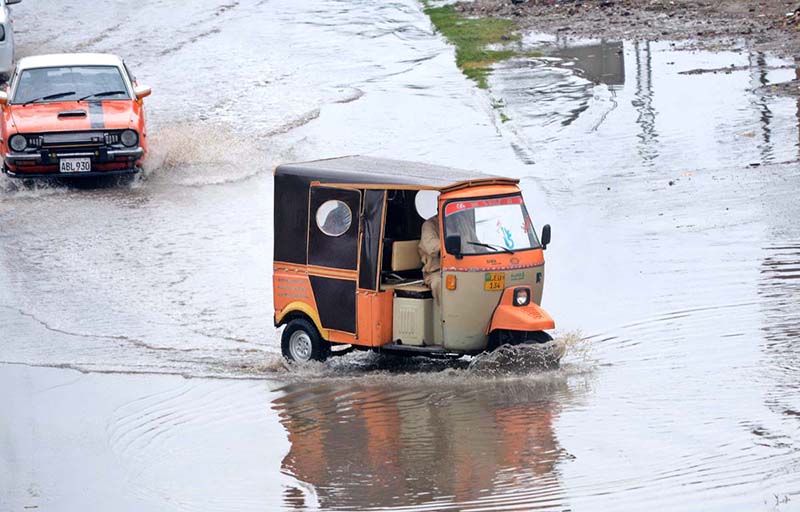 A motorcyclist passing through water accumulated on road during heavy rain that experienced the city
