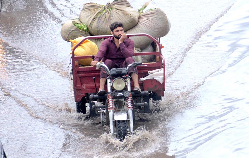 A motorcyclist passing through water accumulated on road during heavy rain that experienced the city