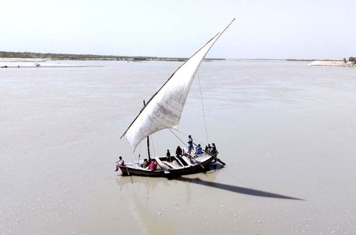 People of Katcha area crossing Indus River through boat near Aqil Village