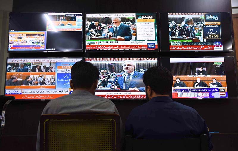 People listening the Federal Budget speech on TV