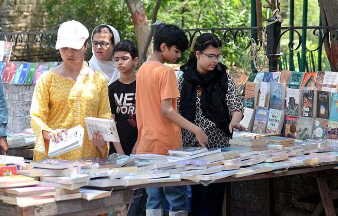 Family selecting old books on a roadside stall at Provincial Capital