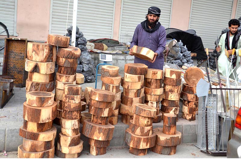 A man displaying equipment of barbeques to attract customers ahead of Eid-ul Azha at Joint Road